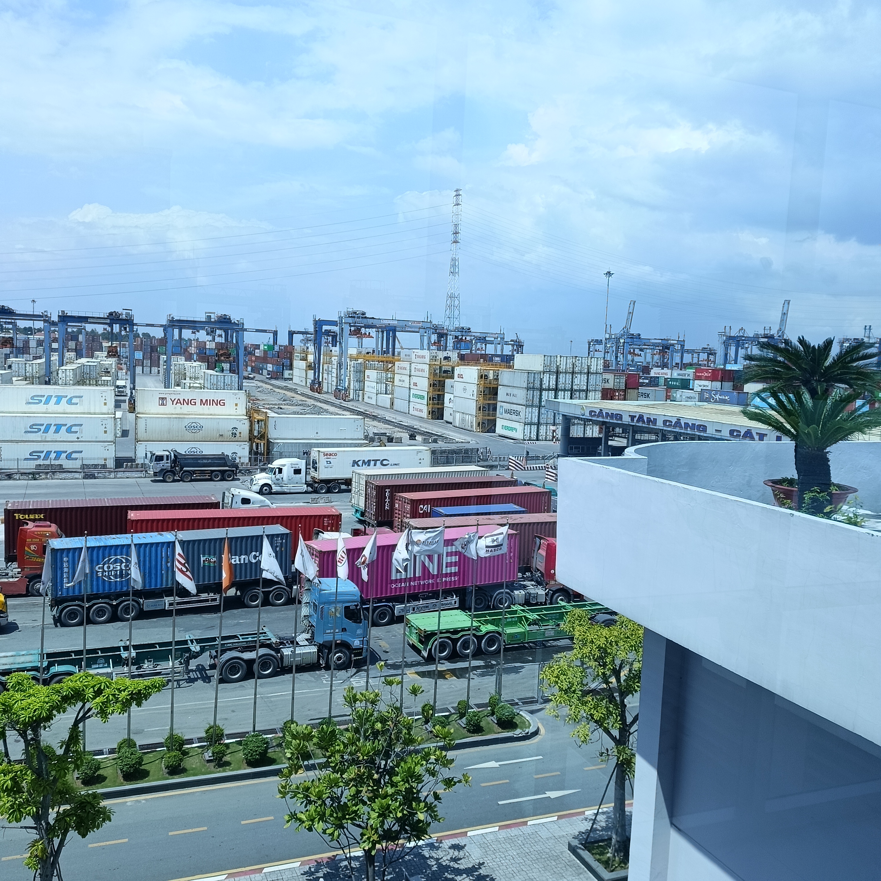 Nhìn từ tầng cao: container SITC, Yang Ming, KMTC xếp hàng dài ra cảng.